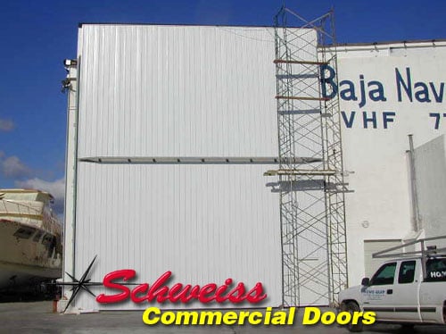 Tall Industrial Bifold Door with Sheeting at a Dockyard