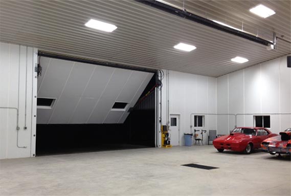 24 ft x 15 ft hydraulic door was custom-made for this mancave/shop