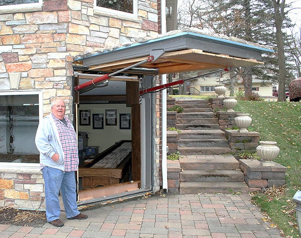 Gene Buboltz stands next Schweiss door on lake home basement