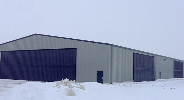 Steel building with Schweiss bifold liftstrap doors has two sizes of door, 60 by 18 and 40 by 16