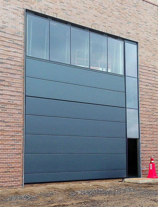 Black Insulated panels and glass on Schweiss door give unique look and natural lighting to university building