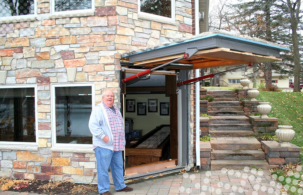 Gene Buboltz in front of his custom Schweiss hydraulic door fitted on his basement