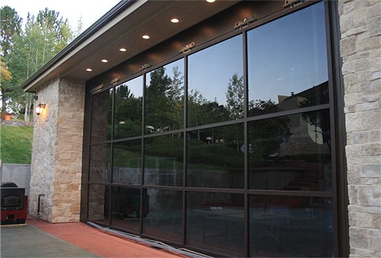 Custom Schweiss glass hydraulic door installed on a garage that opens up to a patio in Denver shown closed