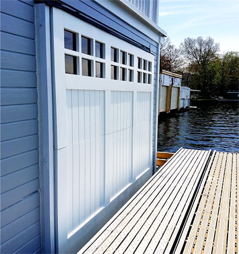 Custom Schweiss bifold door fitted on Michigan boathouse shown closed