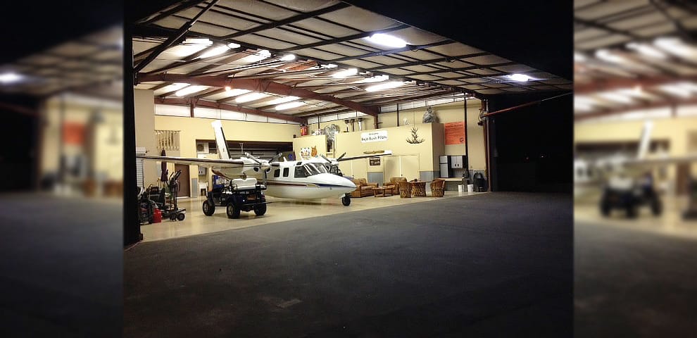 View inside the hangar, the 56x16 ft door open showing an Aero Commander Shrike