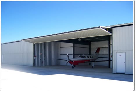 Bifold Door completely opened with airplane inside of hangar with no loss of headroom.