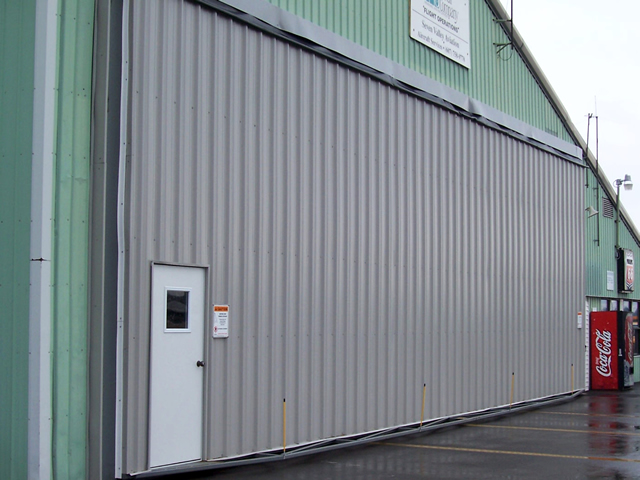 closed hydrualic door with a walk through door on an aircraft hangar