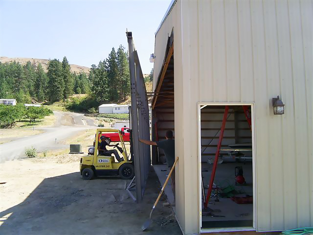 moving hydraulic door into place on building for installation