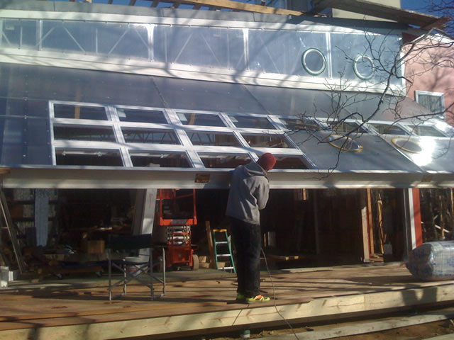 Applying finishing touches to hydraulic aluminum door artist studio in MA