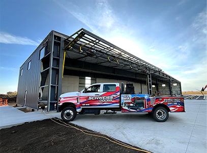 Schweiss install truck parked in front of newly installed Schweiss bifold door shown open