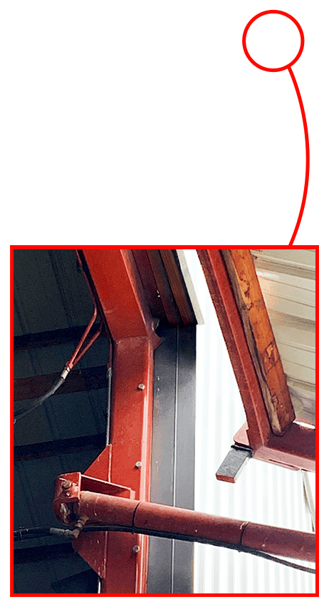 Closeup of cylinders and hinges of hydraulic door that was damaged in a storm - NOT a Schweiss Door