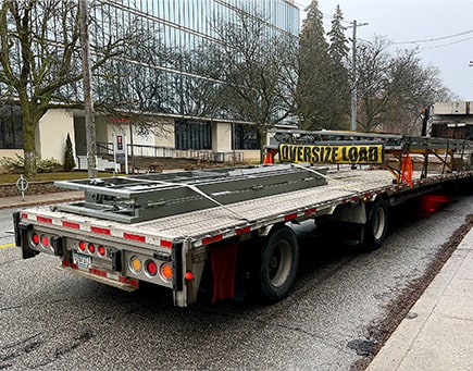 Schweiss bifold shipping container door loaded on delivery trailer for Jeffrey's garage