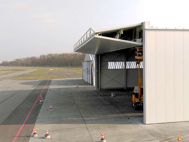 large steel jet hangar has a 93.5 x 26 ft clear bifold liftstrap hangar door
