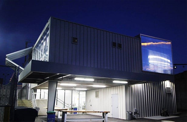 Nighttime glow from building with glass bifold liftstrap door