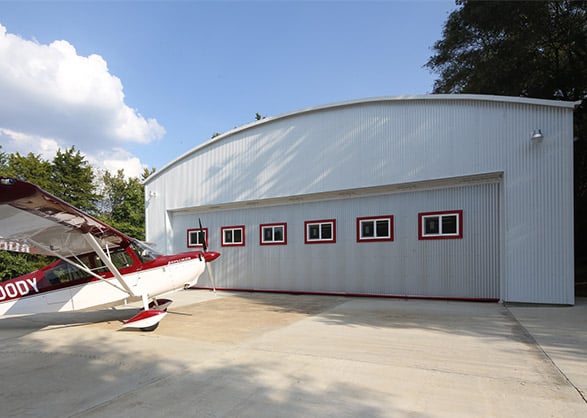 Citabria Explorer easily fits through Schweiss hydraulic door on revamped wood building