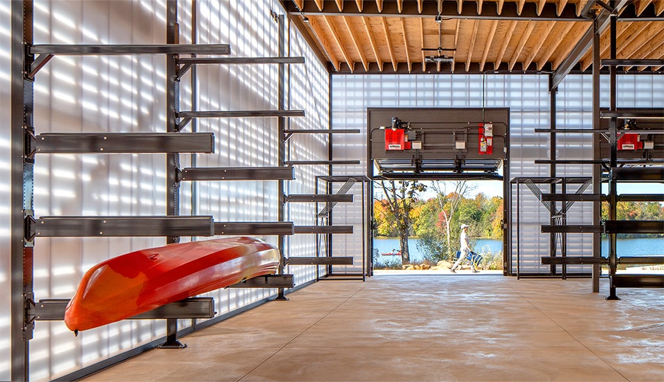 Interior view of storage/crew building at Beaverdam Reservoir Park, showing a kayak resting on a storage rack with Schweiss door in background