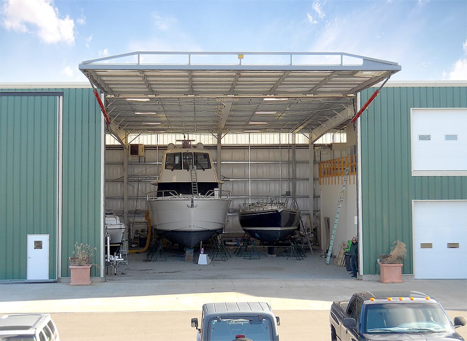 Schweiss hydraulic door fitted on green boat storage yard building shown fully open