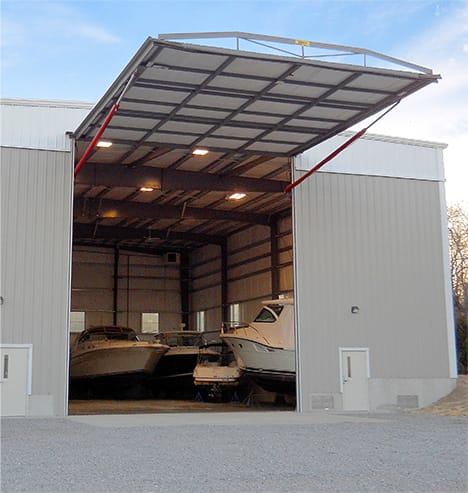 Schweiss hydraulic door fitted on tan boat storage yard building shown fully open
