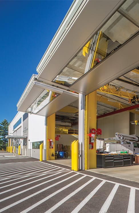 Rightside view of multiple custom Schweiss bifold doors fitted on the BPA Maintenance building shown in the open position