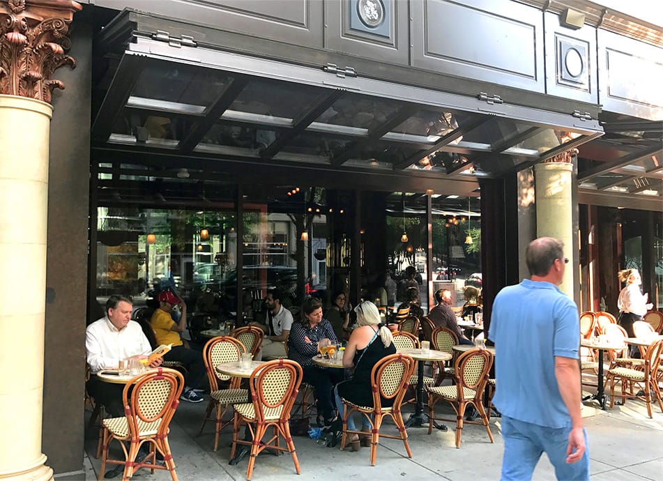 Patrons dining at Cafe Intermezzo underneath open Schweiss bifold doors
