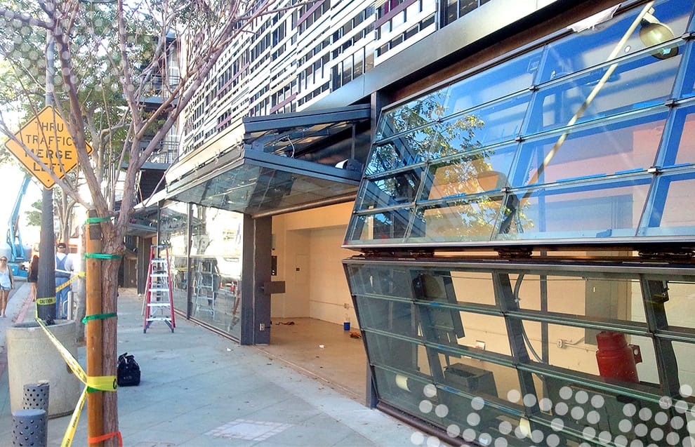 Multiple Schweiss bifold doors in varying positions installed on a bike transit in Santa Monica, CA