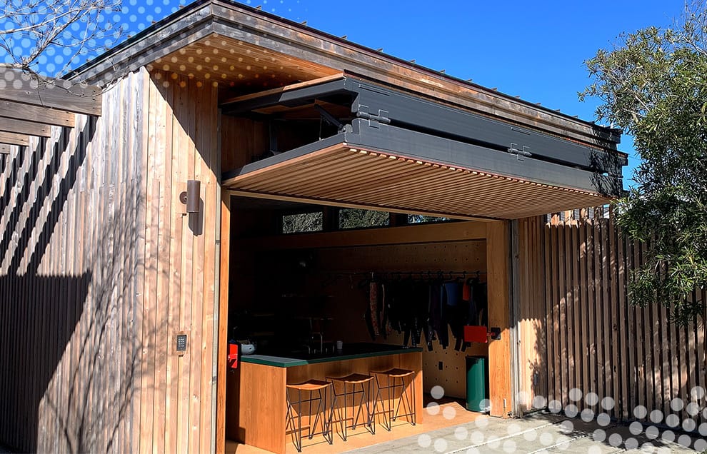 Custom Schweiss bifold door fitted on a custom bar/garage in Santa Cruz, California shown open