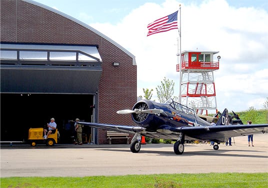 Airplane parked outside of hangar at Fagen WW2 Museum