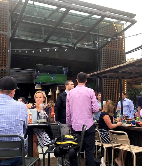 Patrons dining underneath Schweiss glass bifold door fitted on Federales Tequila & Tacos