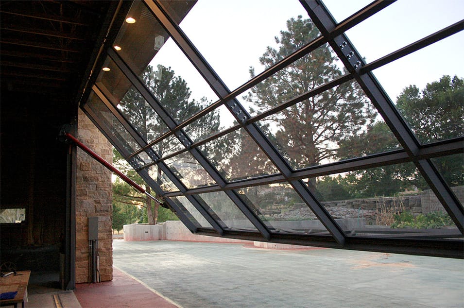 Interior view of custom Schweiss glass hydraulic door installed on a garage that opens up to a patio in Denver