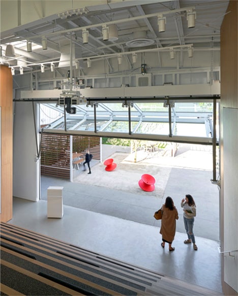 Interior view of Schweiss bifold door installed on Headspace's headquarters, also showing the screen that can glide down to transform the room into an auditorum