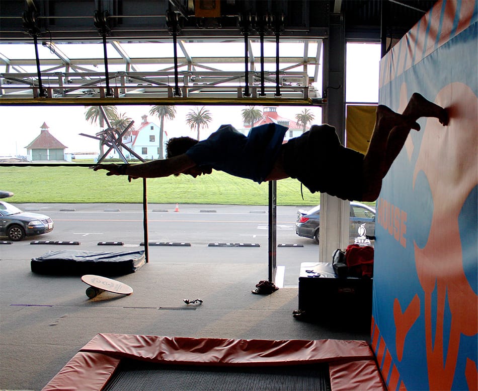 Interior view of House of Air in San Francisco showing someone using a trampoline with a custom Schweiss glass bifold door in the background