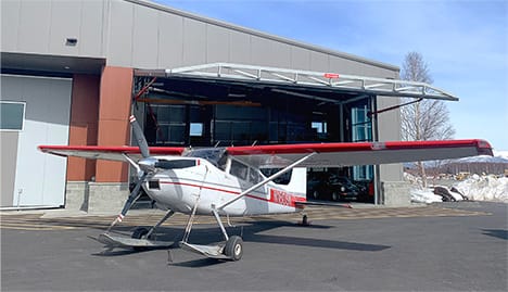 Airplane parked outside of Lake Hood Seaplane Base fitted with Schweiss hydraulic door