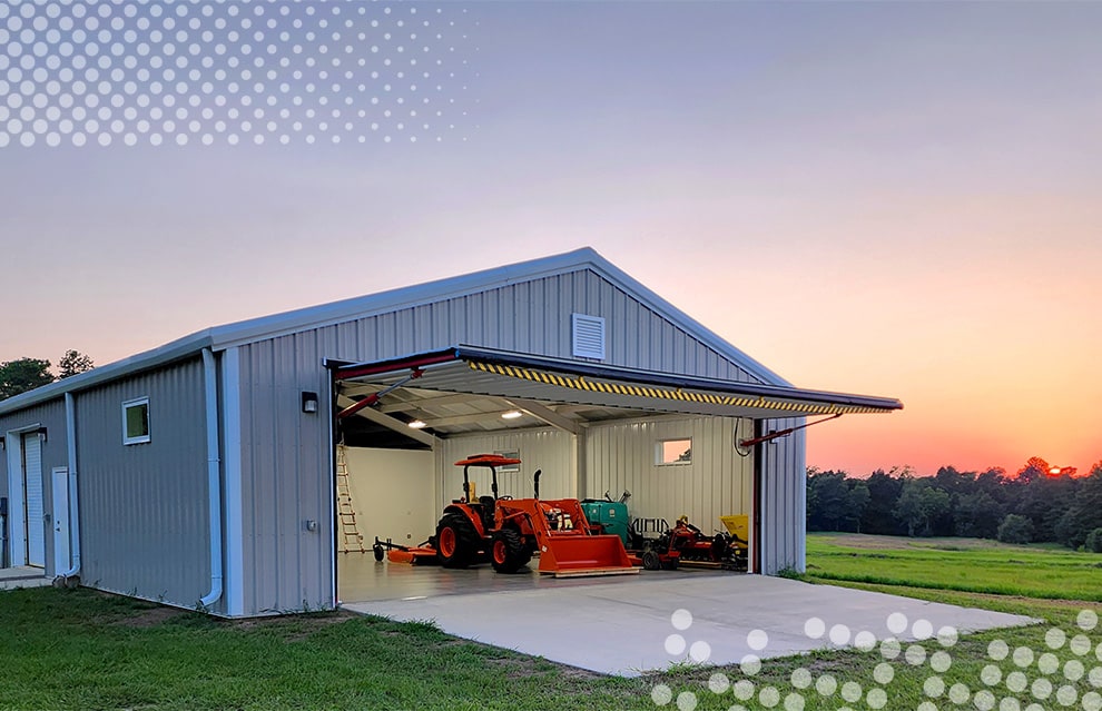 Wide view of Schweiss hydraulic door installed on Mike McLeod's hangar shown open at dusk