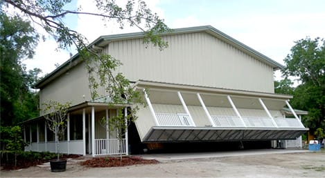 Angled view of a custom Schweiss hydraulic door with an attached porch shown half-open