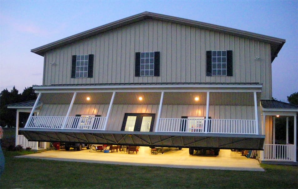 Frontal view of custom Schweiss hydraulic door with an attached porch shown half-open in the evening