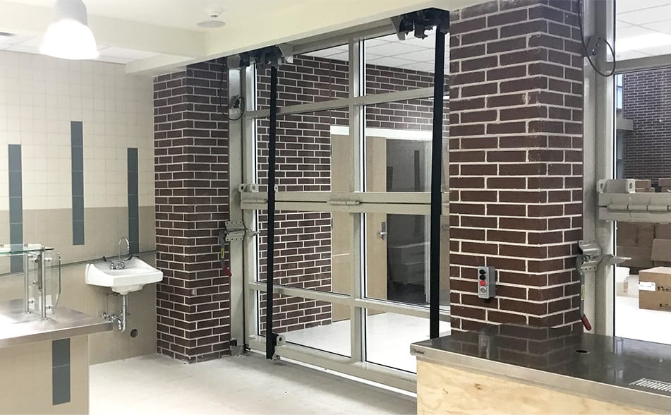 Interior view of a custom Schweiss glass bifold door installed at Infinity Early College High School in New Caney, Texas