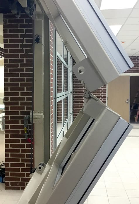 Side view of a custom Schweiss glass bifold door installed at Infinity Early College High School in New Caney, Texas shown half open