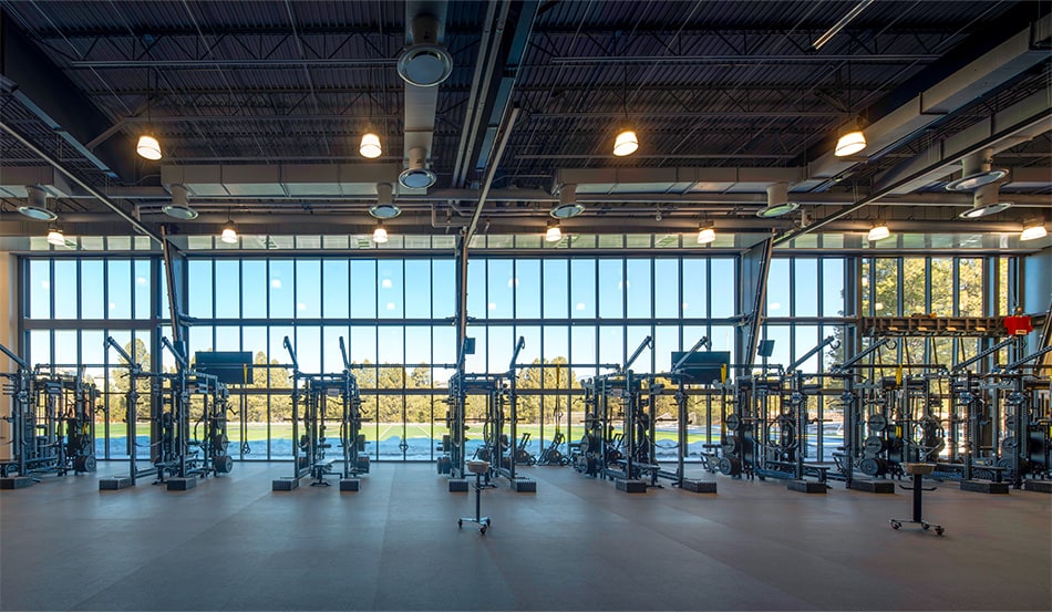 Interior view of the weight room in NAU's Student-Athlete High-Performance Center, where a Schweiss bifold door is installed