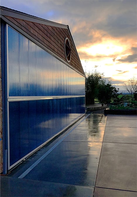 Angled picture showing Schweiss bifold door installed on Oregon Star Hangar at dusk