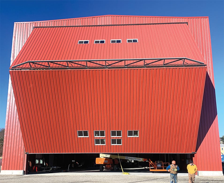 Frontal view of Portland Yacht Services building fitted with large Schweiss bifold door shown opening