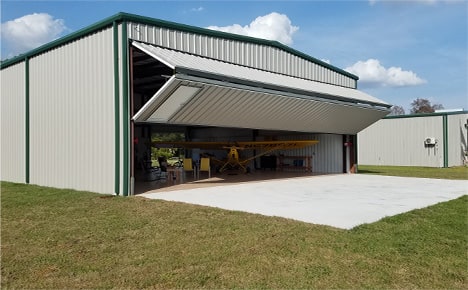 Schweiss bifold liftstrap door installed on Ray Cook's hangar shown opening