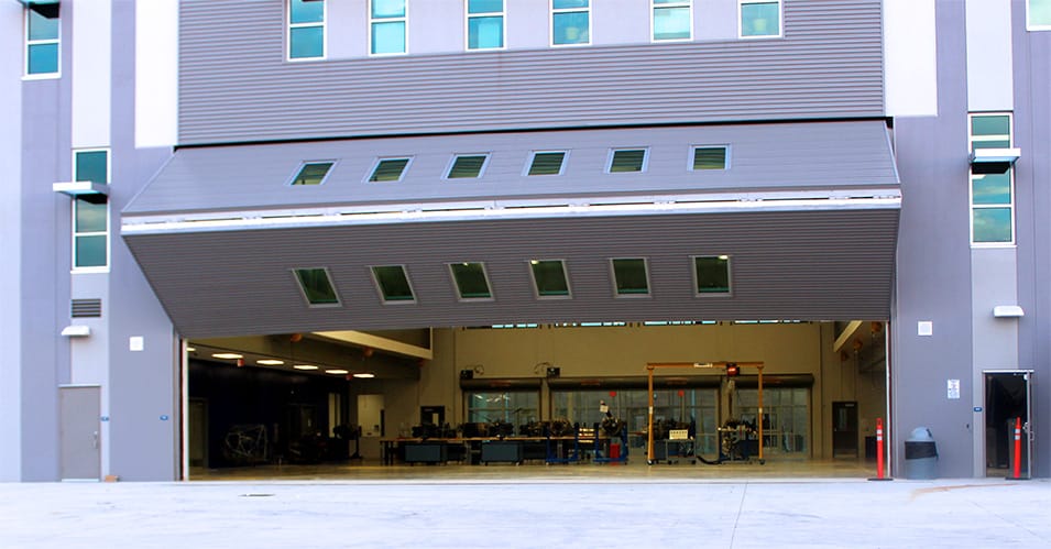 Exterior view of Schweiss bifold liftstrap door fitted at Sterling Aviation HS shown opening