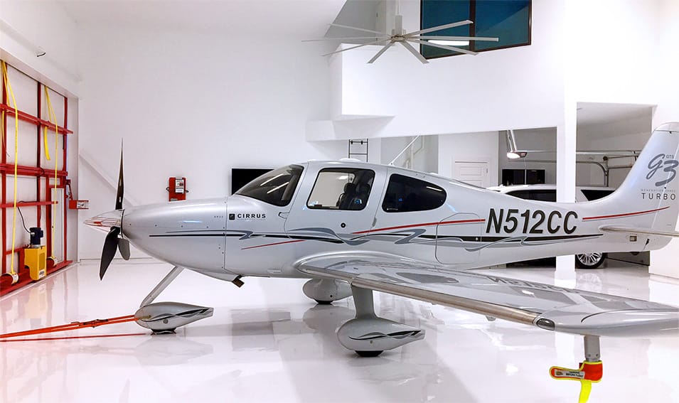 Cirrus SR22 G3 Turbo airplane parked inside Texas Hangar Home fitted with Schweiss bifold door