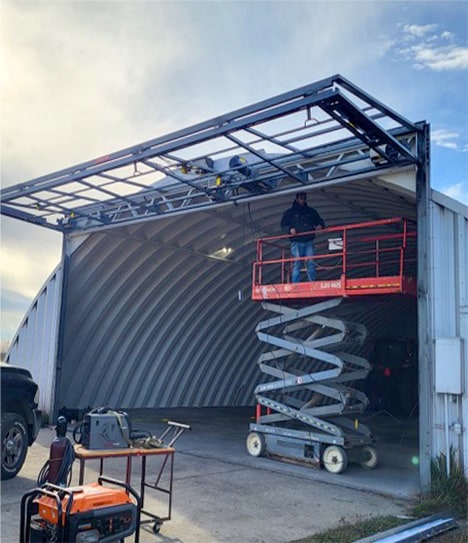 Upper Midwest Garage Door LLC installing Schweiss bifold frame onto quonset shed in South Dakota