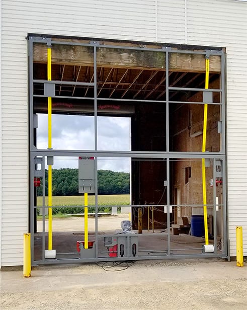 View of the frame of the new Schweiss bifold liftstrap door fitted on West Wisconsin Ag Supply during installation