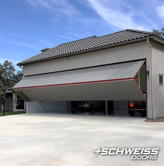 Schweiss Bifold Door with red frame and mandoor at Texas Airpark