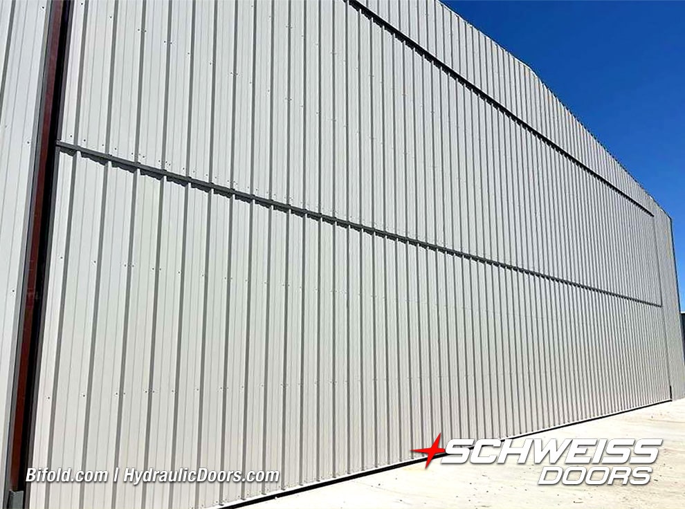 Exterior view of 100ft Schweiss bifold hangar door installed on storage hangar shown closed