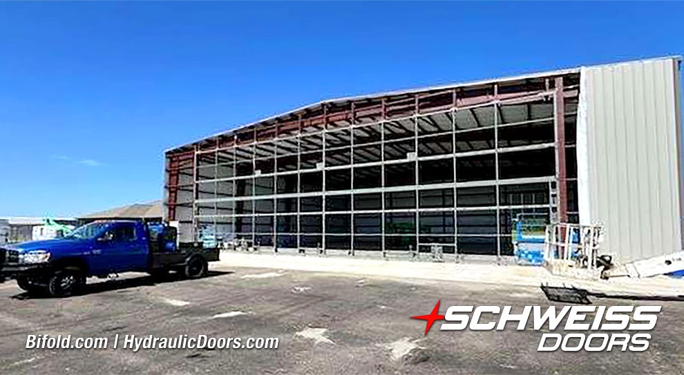 Exterior view of 100ft Schweiss bifold frame installed on storage hangar shown closed
