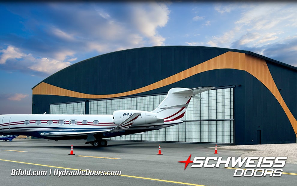 Exterior view of 120ft Schweiss hydraulic hangar door behind large plane shown closed
