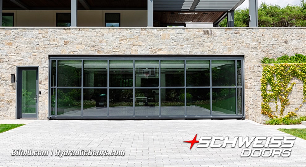 View from front of Schweiss custom glass hydraulic door fitted on luxury garage shown closed